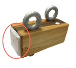 Wooden block with metal rings on top, highlighted by a red circle.